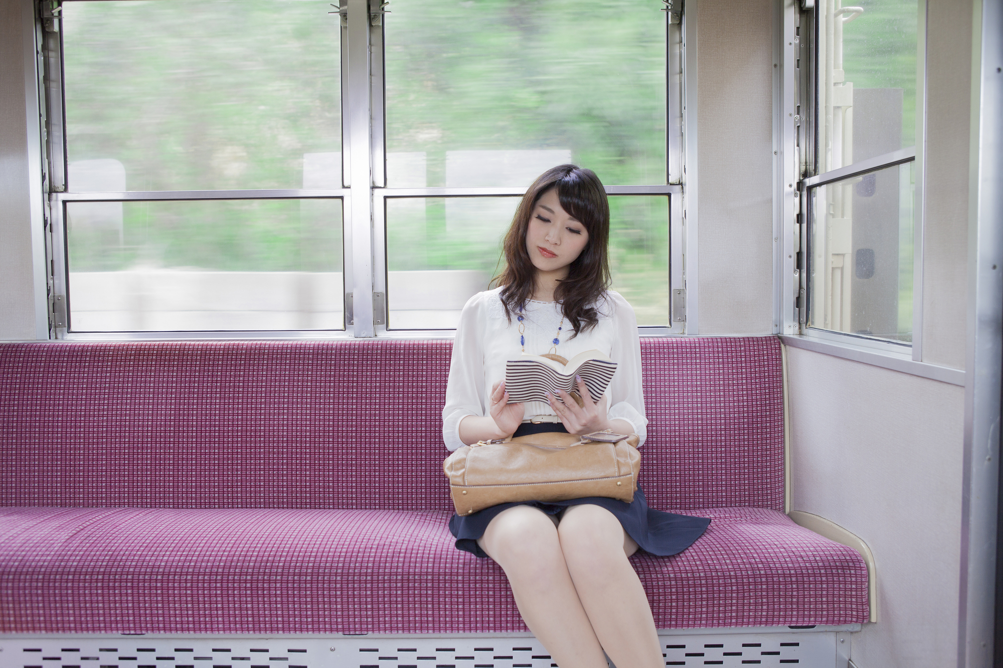 電車で読書をする女性